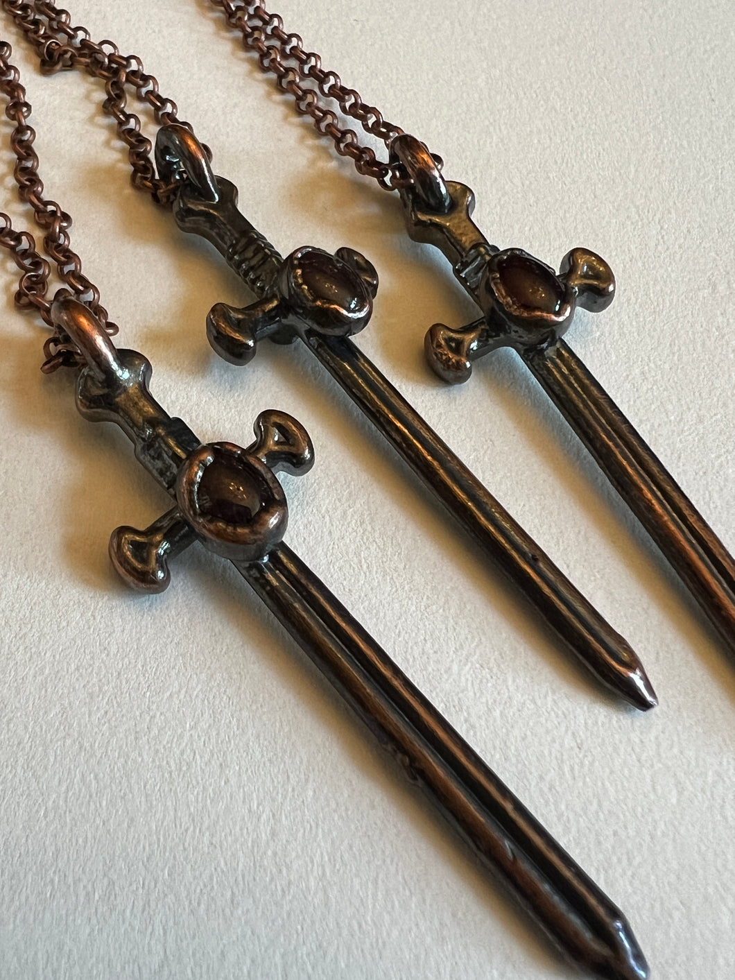 Copper garnet sword necklace
